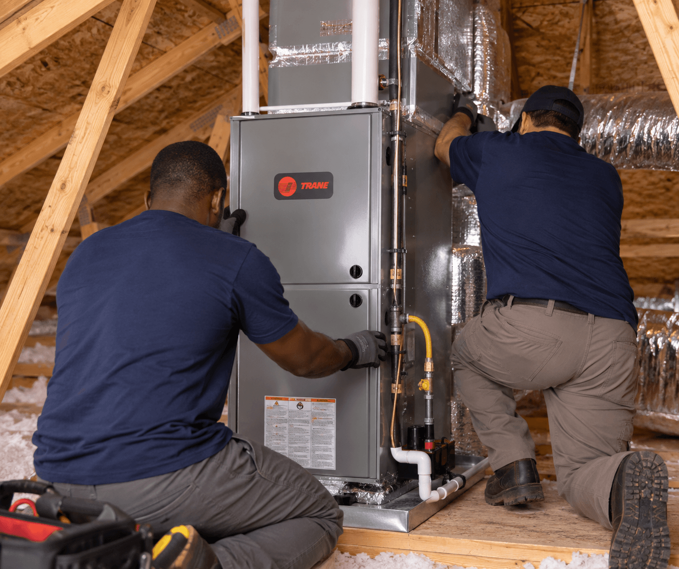 Hensley technicians installing a Trane heating system in an attic
